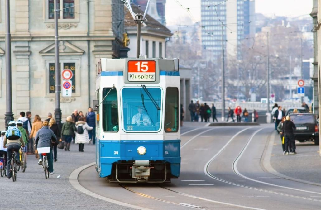 Straßenbahn Linie 15 in Zürich, umgeben von Radfahrern und Fußgängern – typische Verkehrsszene in der Innenstadt.