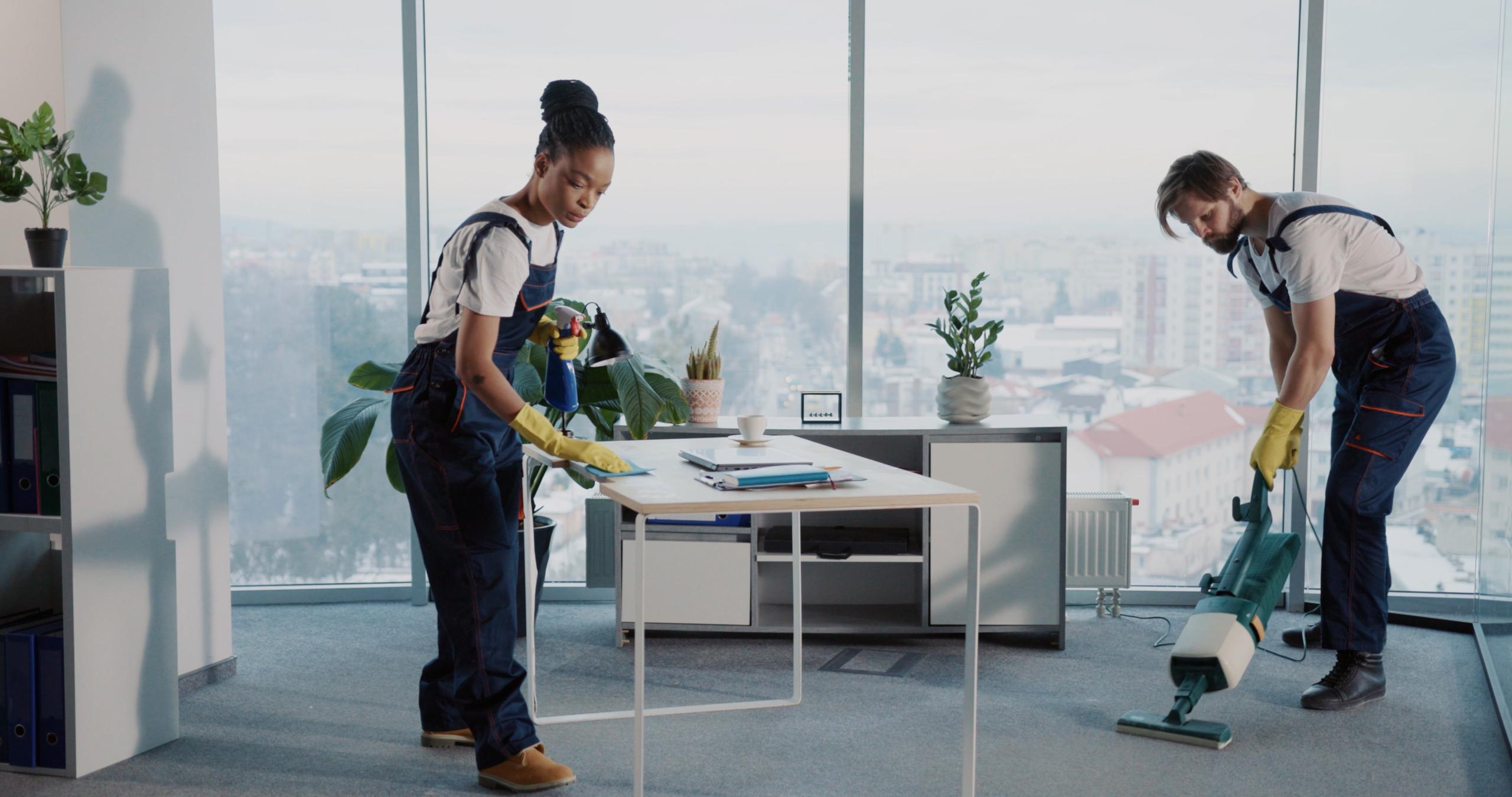 Zwei Reinigungskräfte reinigen ein modernes Büro in Berlin – Arbeitsplatzhygiene durch professionelle Büroreinigung.