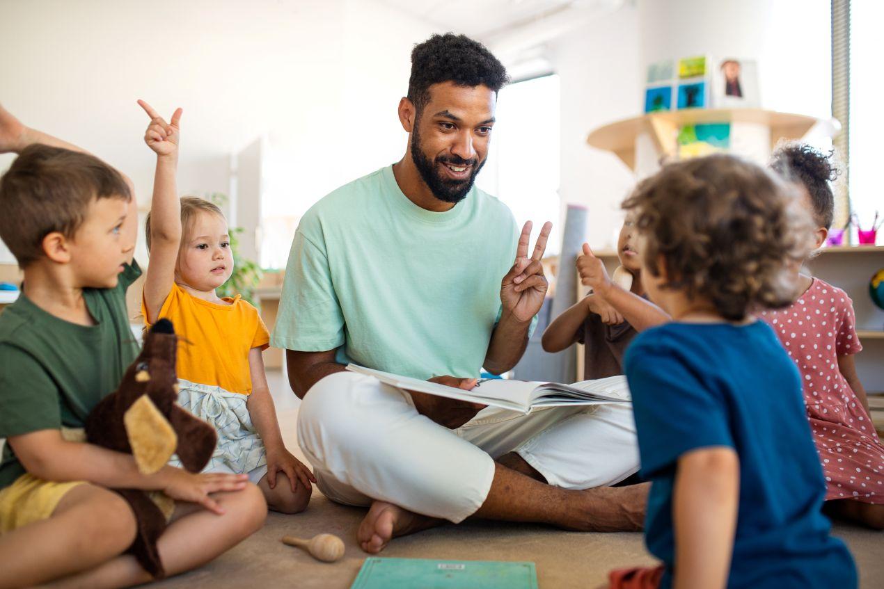 Erzieher mit Kindern im Morgenkreis – Kita Assistenz unterstützt die pädagogische Arbeit im Kita-Alltag