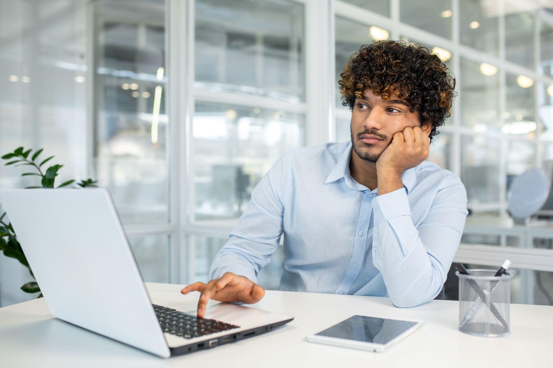 Junger Mann mit Denkpause im Büro – Selbstmanagement Coaching