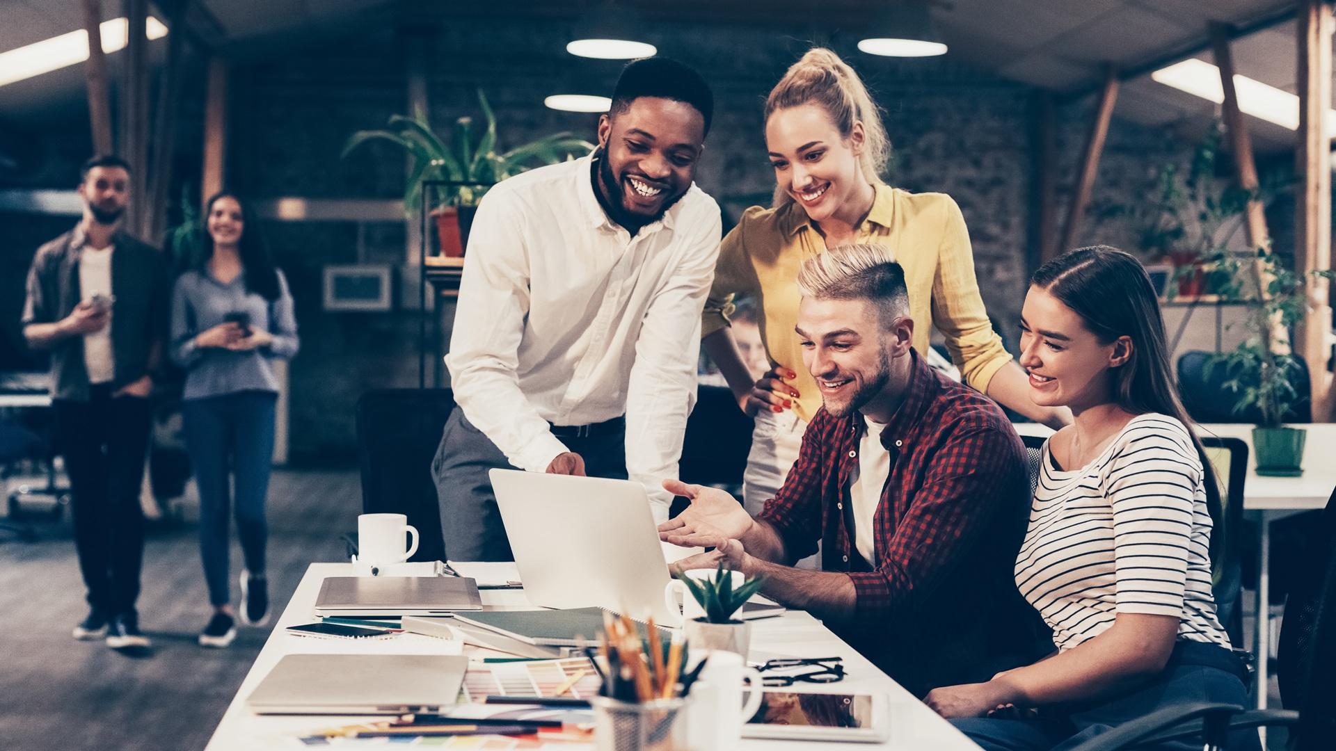 Team arbeitet gemeinsam am Laptop | betriebliches Gesundheitsmanagement