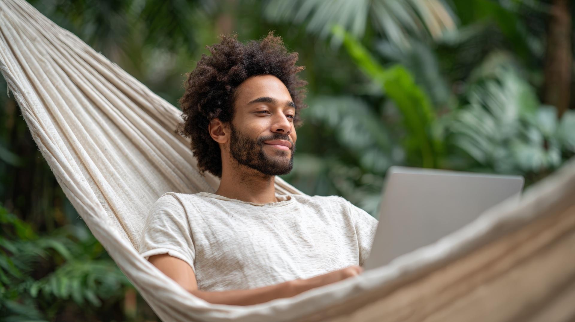 Mann arbeitet am Laptop in Hängematte | Jobs am Meer