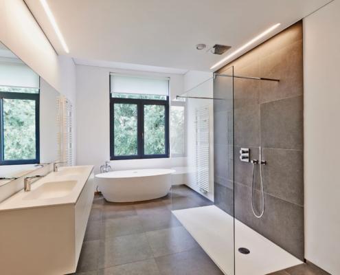 Modernes Badezimmer mit Dusche, Badewanne und Boden aus Klickfliese in grauer Steinoptik für pflegeleichte Gestaltung