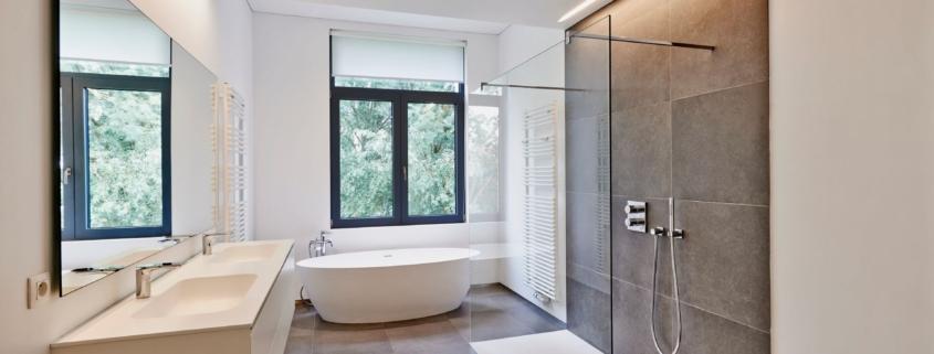 Modernes Badezimmer mit Dusche, Badewanne und Boden aus Klickfliese in grauer Steinoptik fuÌr pflegeleichte Gestaltung