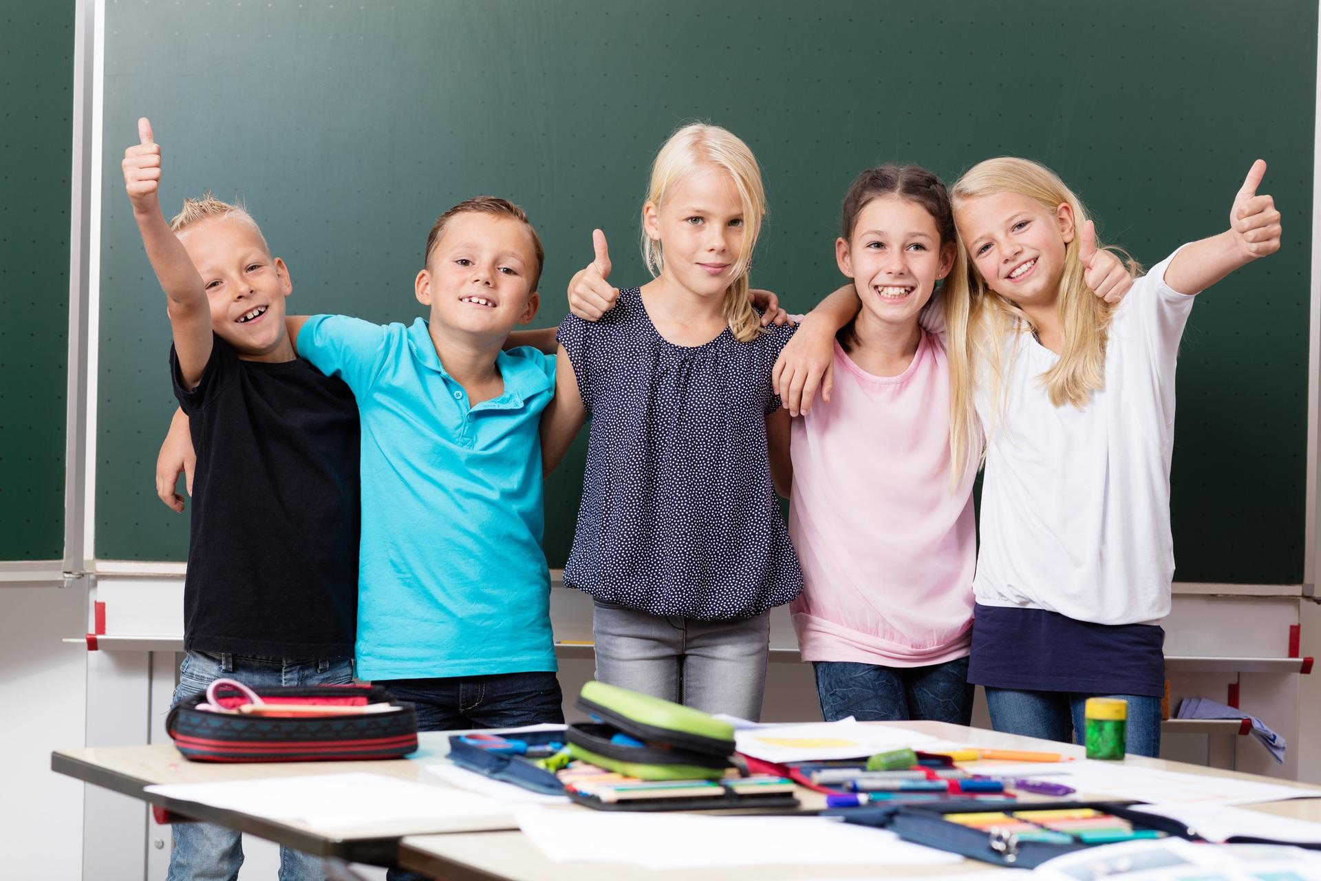 Fünf Schüler mit Daumen hoch im Klassenzimmer | Grundschule Berlin