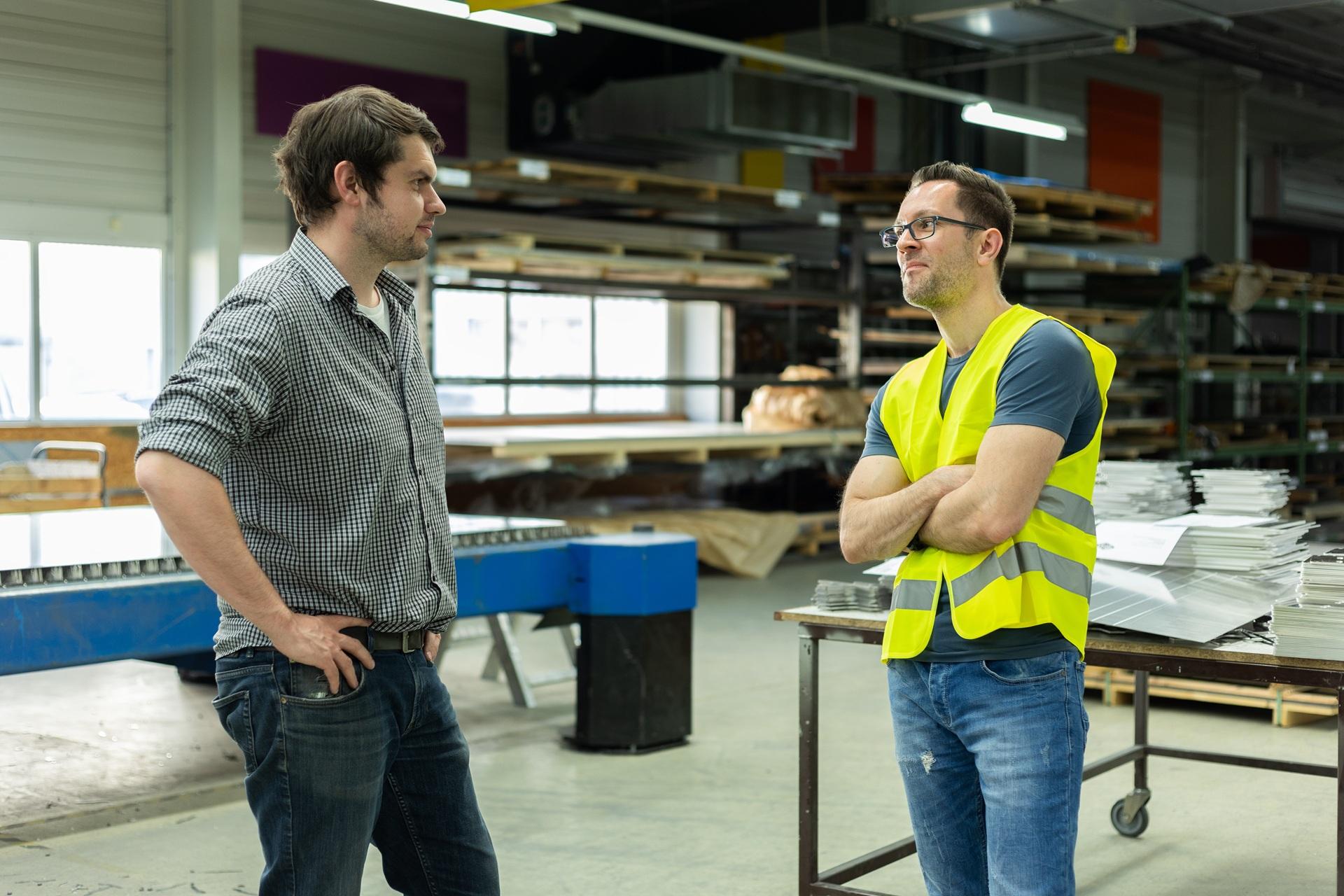 Fachgespräch zweier Kollegen in Produktionshalle | Schweißrauchabsaugung