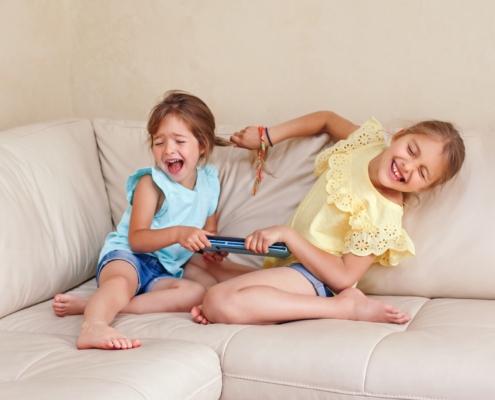 Zwei Kinder streiten lachend um ein Tablet | Kindergarten Schwabing