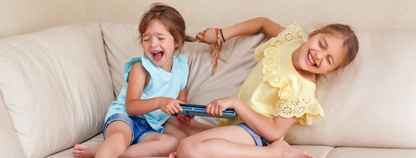 Zwei Kinder streiten lachend um ein Tablet | Kindergarten Schwabing